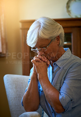 Buy stock photo Cropped shot of a senior woman looking worried with her hands clasped together at home