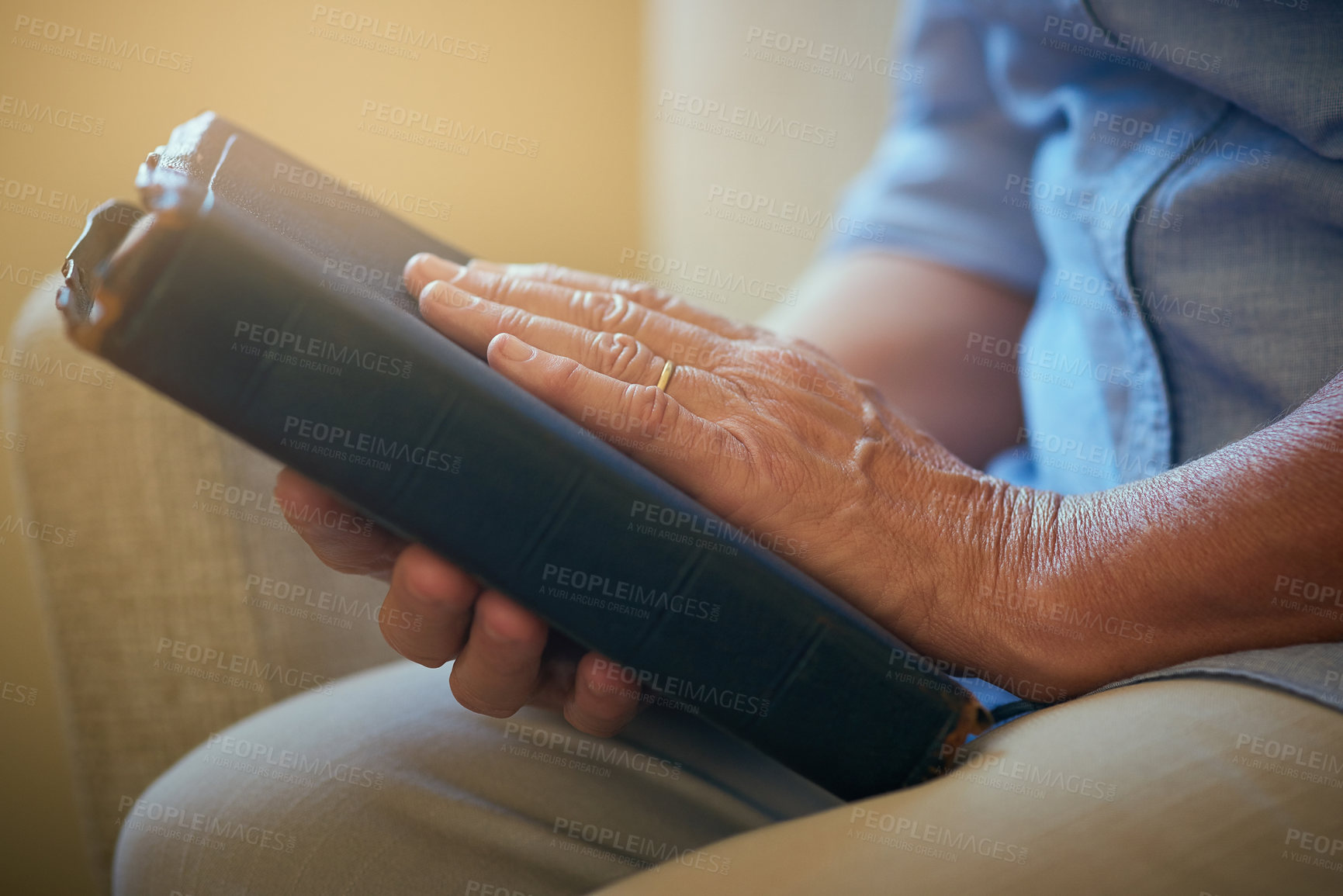 Buy stock photo Closeup shot of a senior woman holding a Bible at home