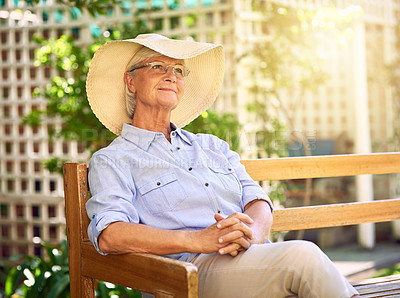 Buy stock photo Shot of a thoughtful senior woman relaxing on a bench in the garden