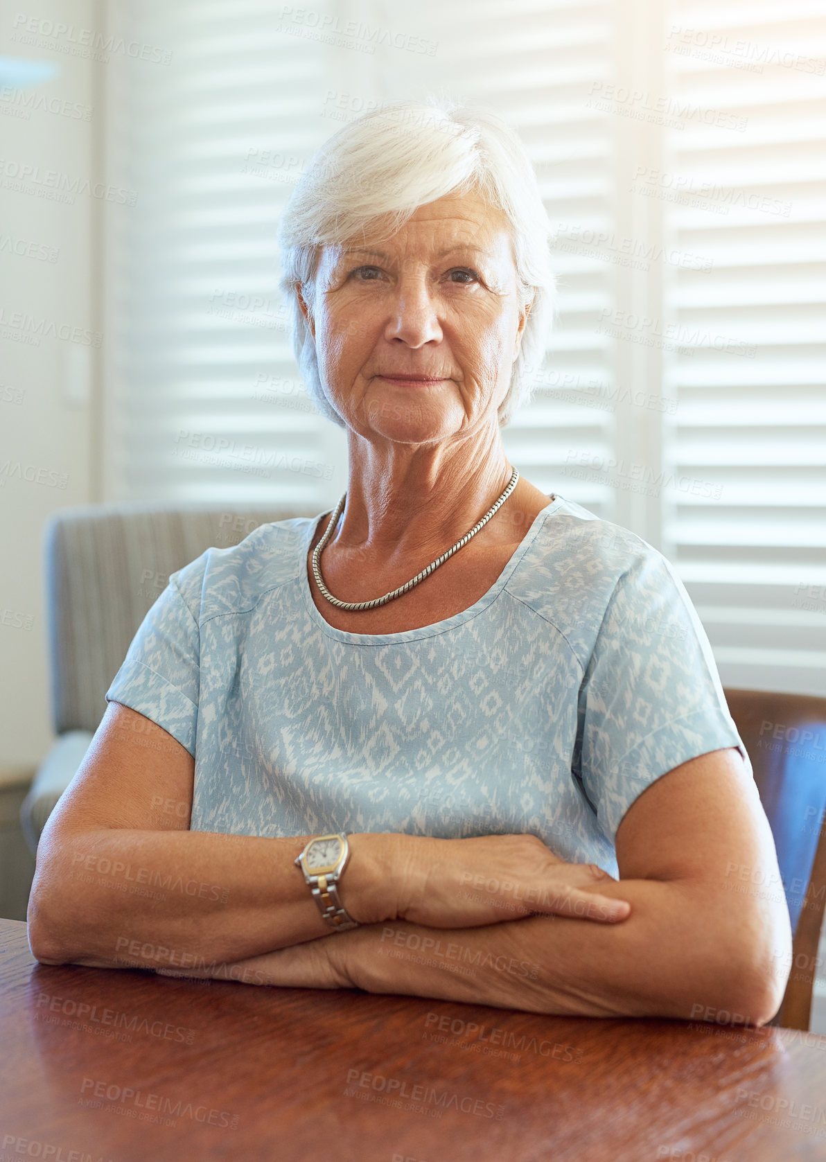 Buy stock photo Smile portrait and senior woman sitting in retirement home, wellness and comfort for care. Happy, healthy and calm elderly person seated on table, relaxation at nursing house and rehabilitation