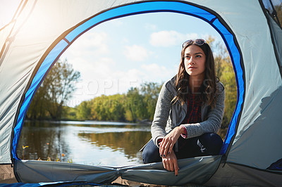 Buy stock photo Full length shot of an attractive young woman sitting at her campsite