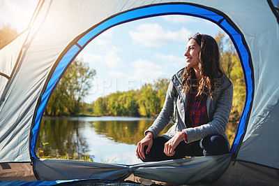 Buy stock photo Full length shot of an attractive young woman sitting at her campsite