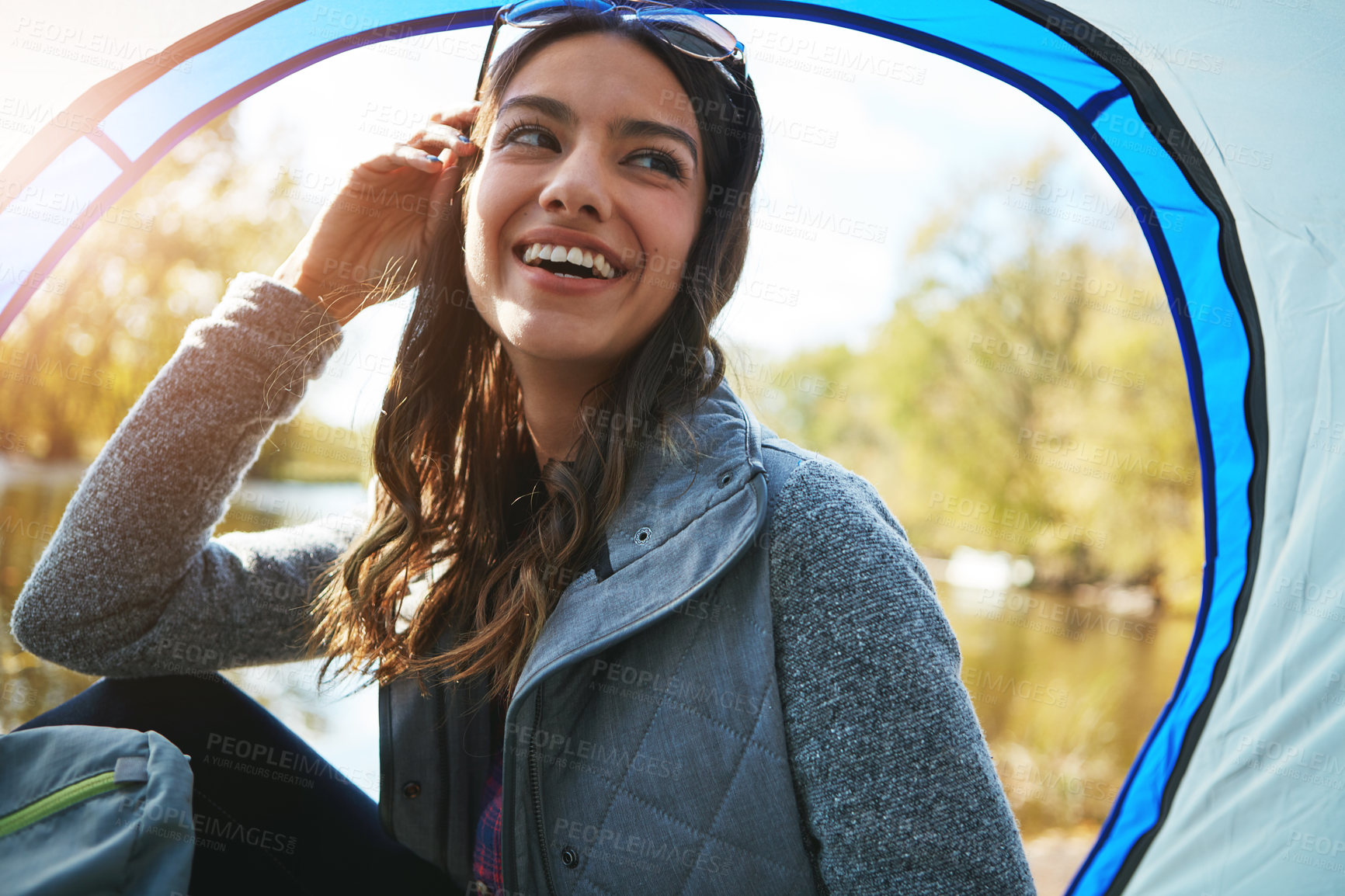 Buy stock photo Cropped shot of an attractive young woman sitting at her campsite