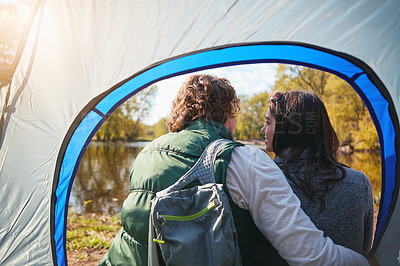 Buy stock photo Rearview shot of an affectionate young couple sitting at their campsite