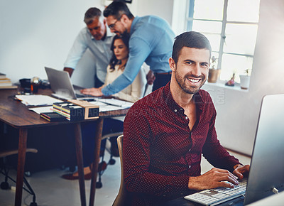 Buy stock photo Portrait of a young man working in the office with his colleagues in the background