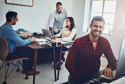 Buy stock photo Portrait of a young man working in the office with his colleagues in the background