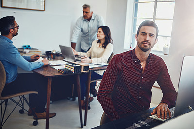 Buy stock photo Portrait of a young man working in the office with his colleagues in the background