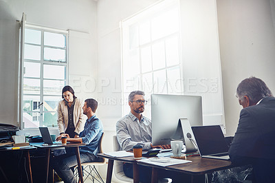 Buy stock photo Shot of a group of colleagues at work in a modern office