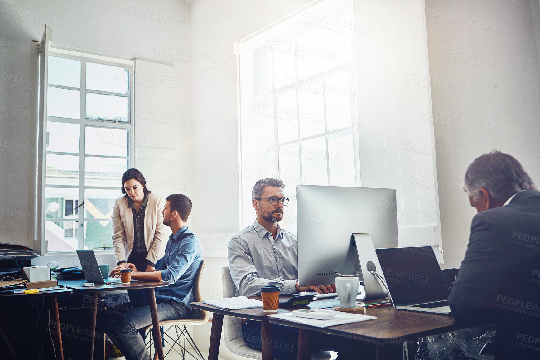 Buy stock photo Shot of a group of colleagues at work in a modern office