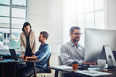Buy stock photo Office, computer and businessman with his colleagues talking or discussing in the background. Pc, success and mature professional male employee working on a corporate company report in the workplace.