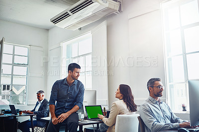 Buy stock photo Shot of colleagues having a discussion in a modern office