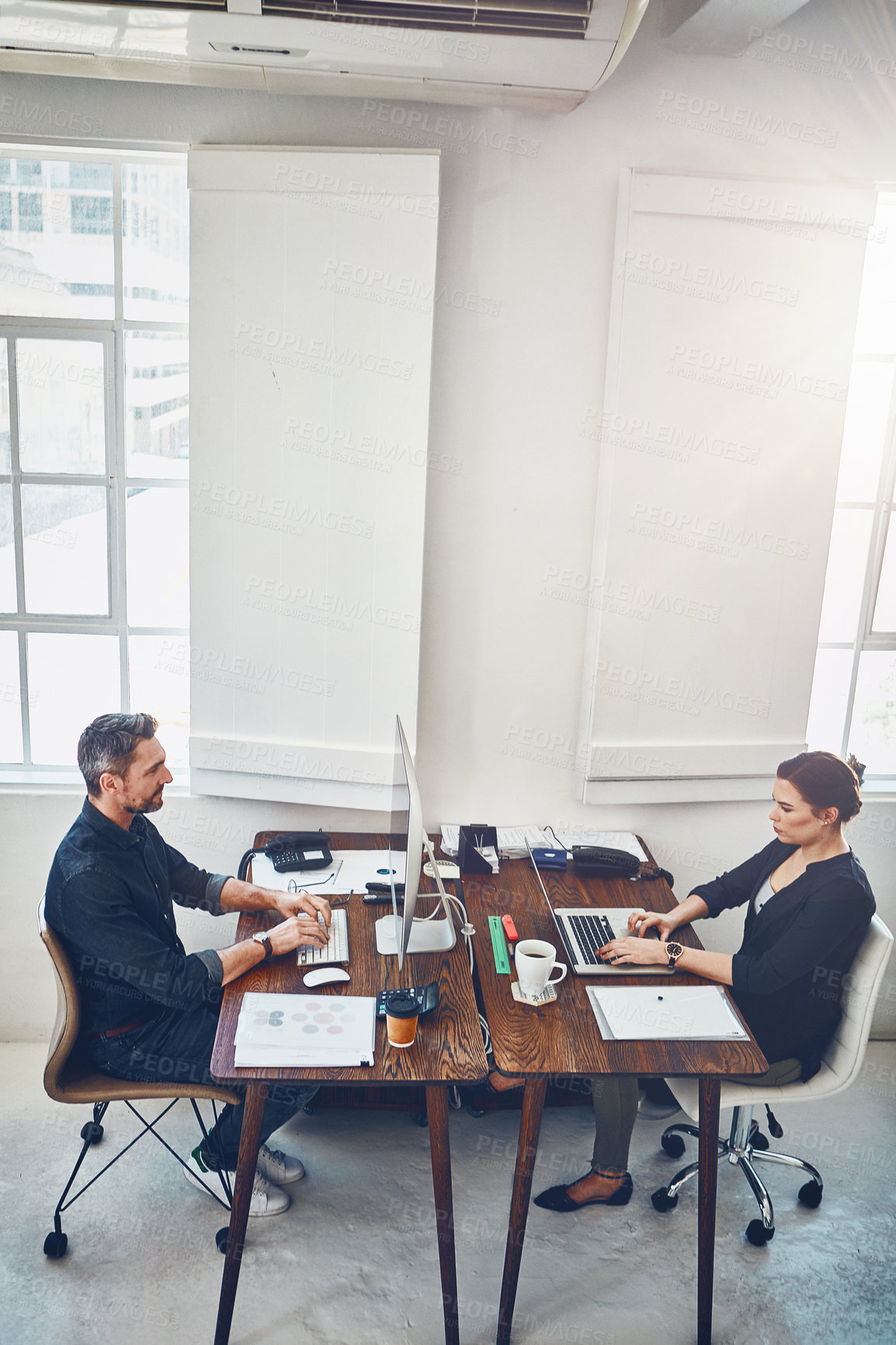 Buy stock photo Laptop, computer and business people with opposite desk in office workplace. Planning, strategy and workers, man and woman with computers typing or working on sales, marketing or advertising project.
