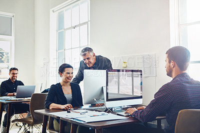 Buy stock photo Shot of colleagues using a computer together in a modern office