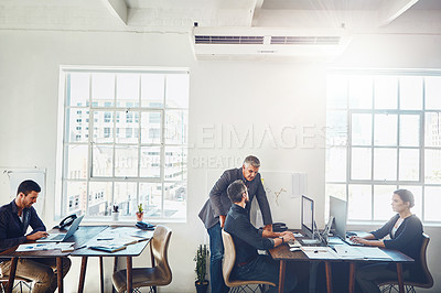 Buy stock photo Shot of colleagues using a computer together in a modern office