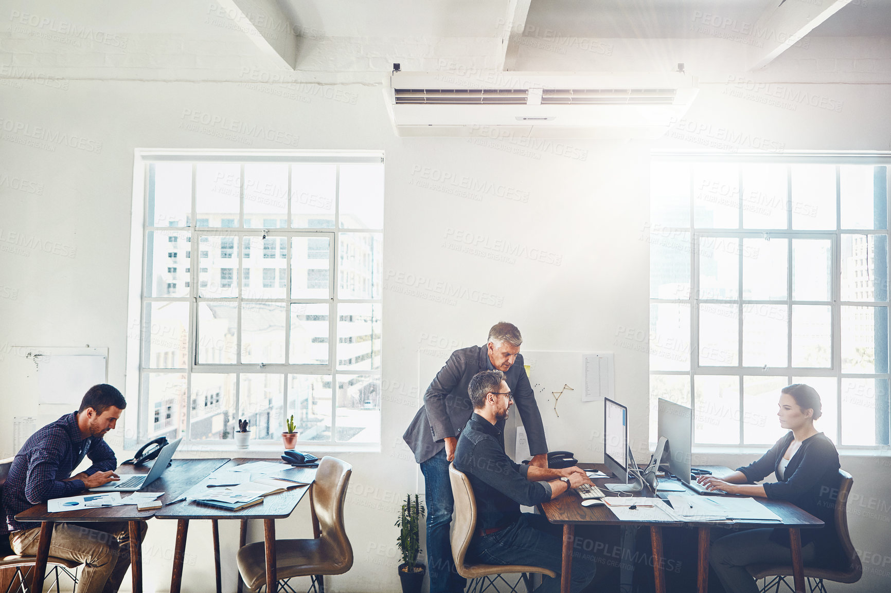 Buy stock photo Shot of colleagues using a computer together in a modern office