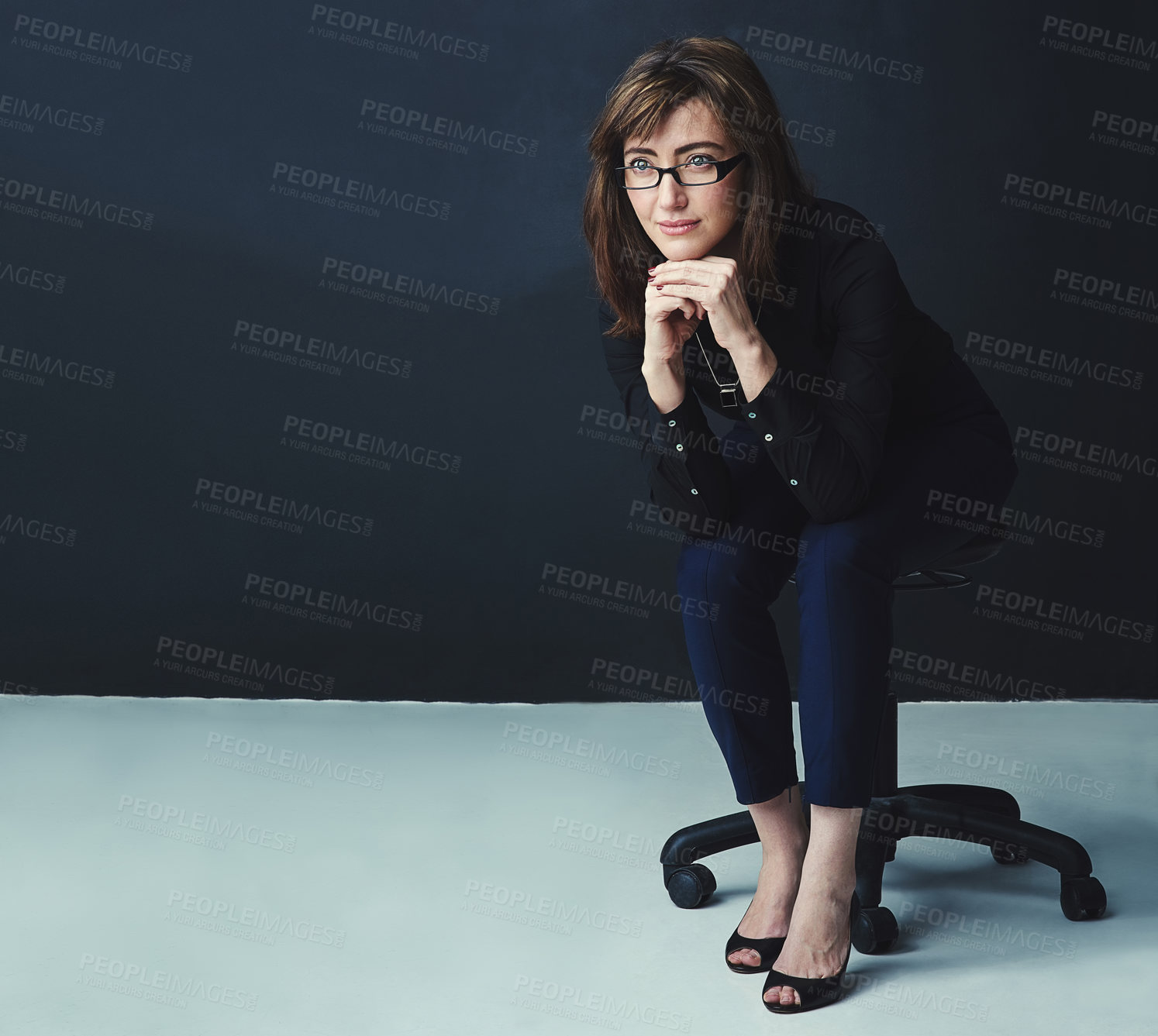 Buy stock photo Studio shot of a corporate businesswoman looking thoughtful against a dark background