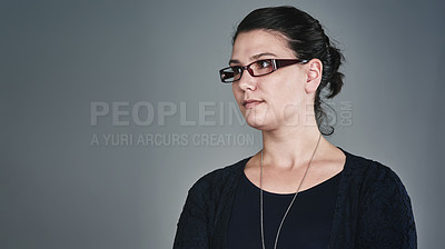 Buy stock photo Studio shot of a young businesswoman posing against a grey background