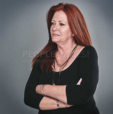 Buy stock photo Studio shot of a mature businesswoman looking thoughtful against a grey background