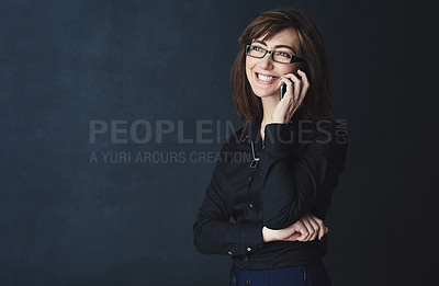 Buy stock photo Studio shot of a corporate businesswoman talking on a cellphone against a dark background
