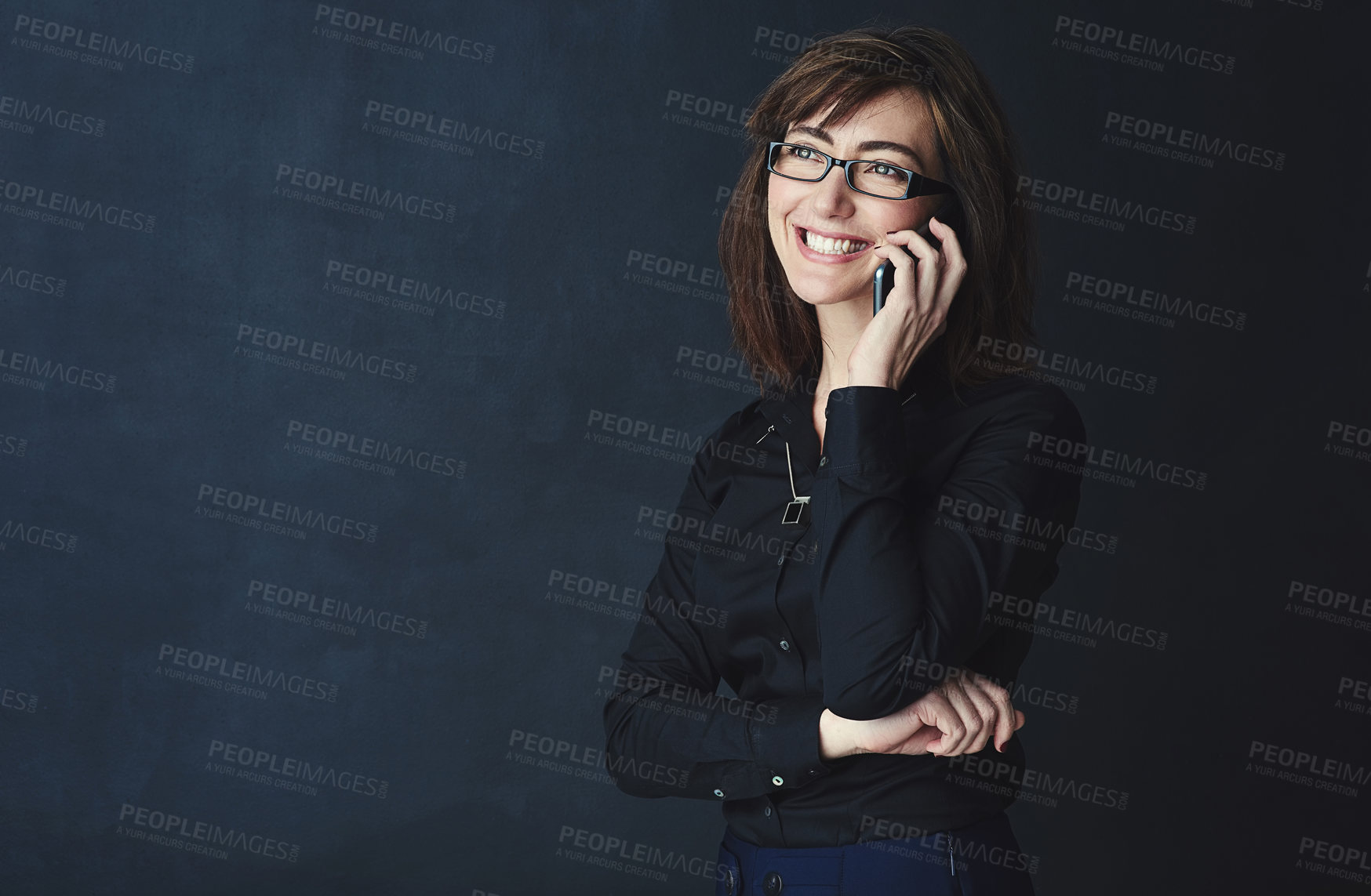 Buy stock photo Studio shot of a corporate businesswoman talking on a cellphone against a dark background