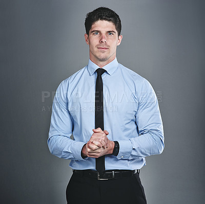 Buy stock photo Studio portrait of a young businessman posing against a grey background