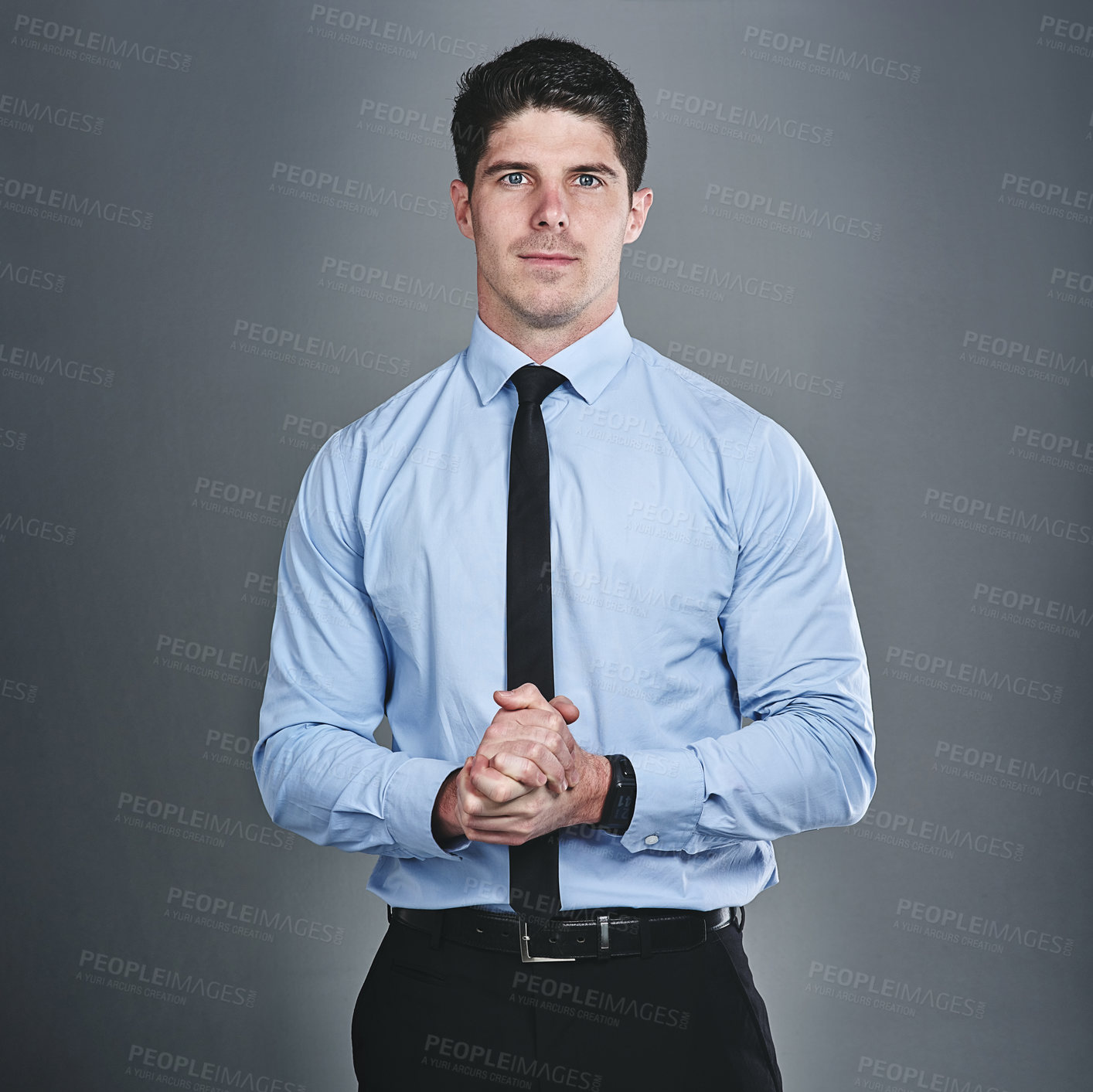 Buy stock photo Studio portrait of a young businessman posing against a grey background