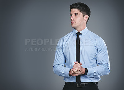 Buy stock photo Studio shot of a young businessman posing against a grey background