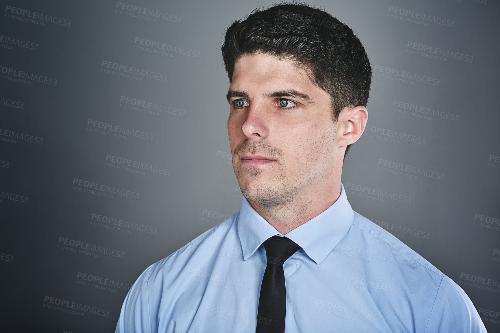 Buy stock photo Studio shot of a young businessman looking thoughtful against a grey background