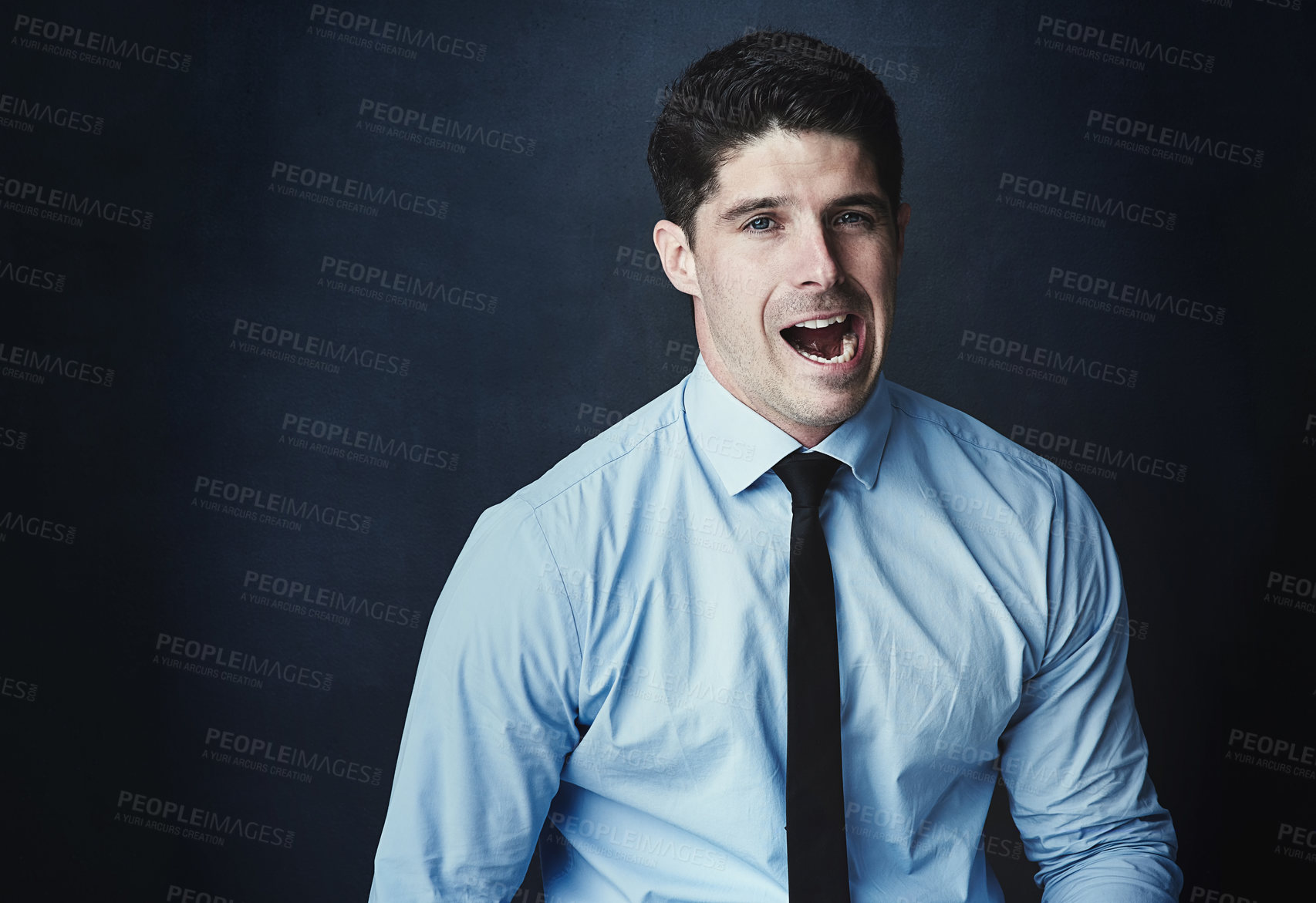 Buy stock photo Studio portrait of a young businessman making a face against a dark background