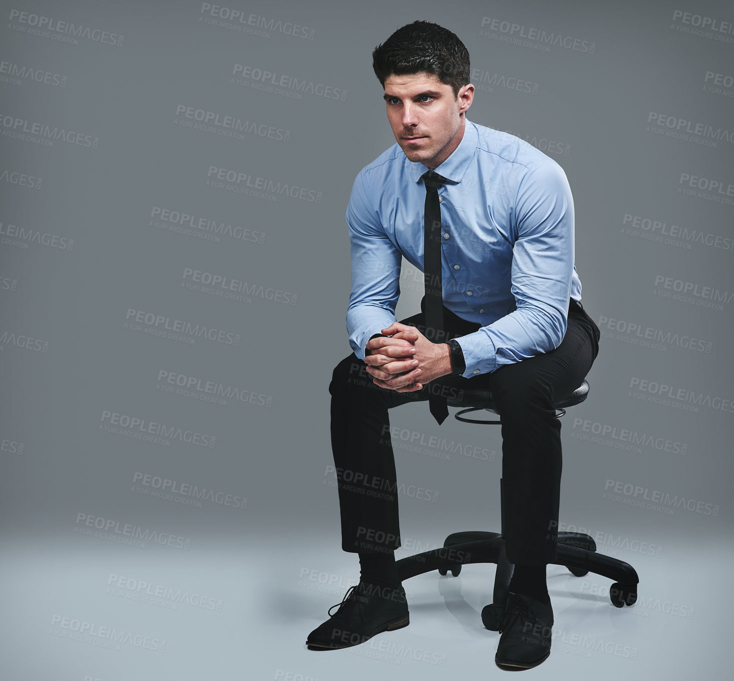 Buy stock photo Studio shot of a young businessman looking thoughtful against a grey background