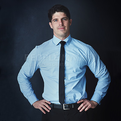 Buy stock photo Studio portrait of a young businessman posing against a dark background