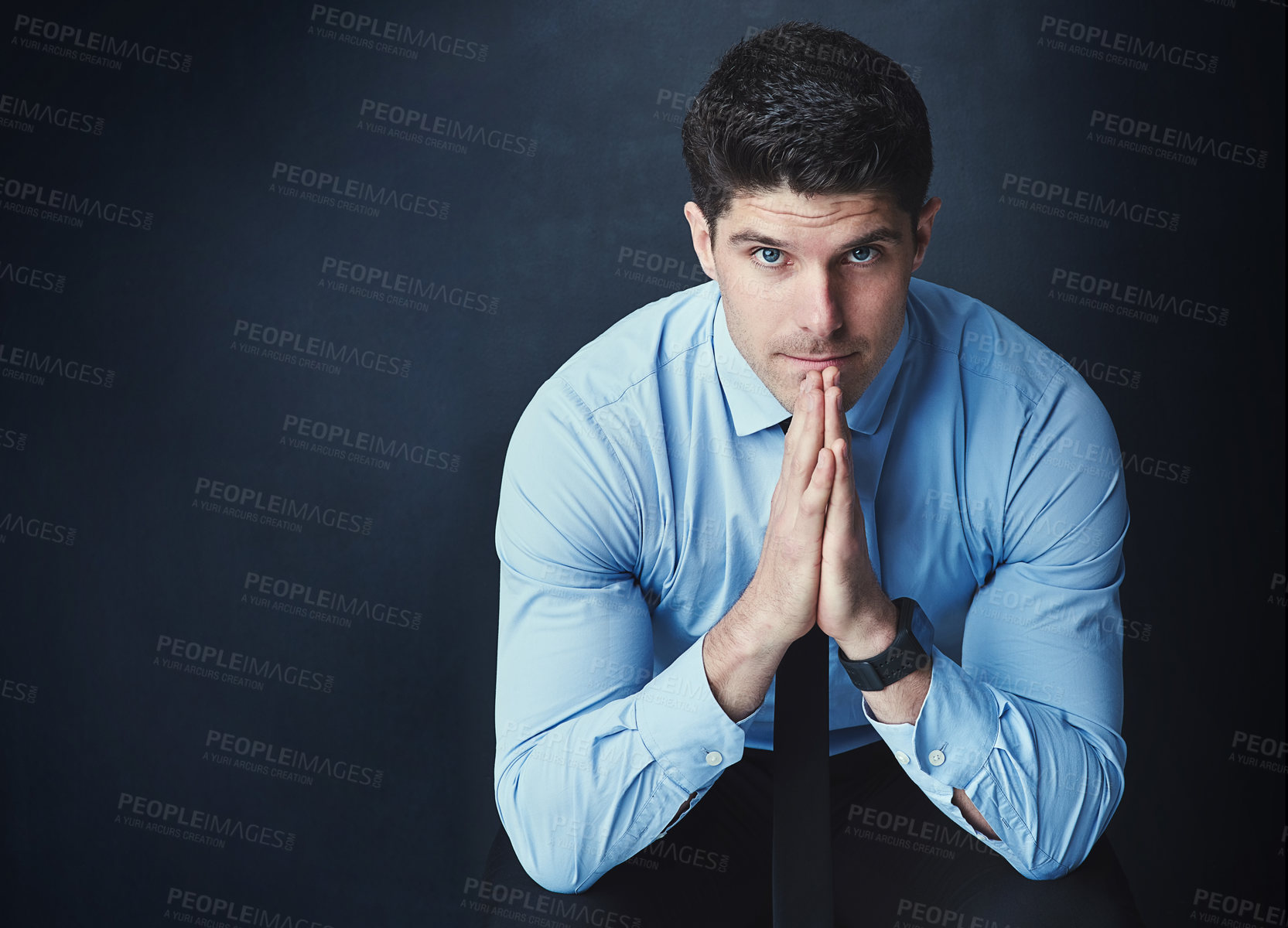 Buy stock photo Studio portrait of a young businessman posing against a dark background