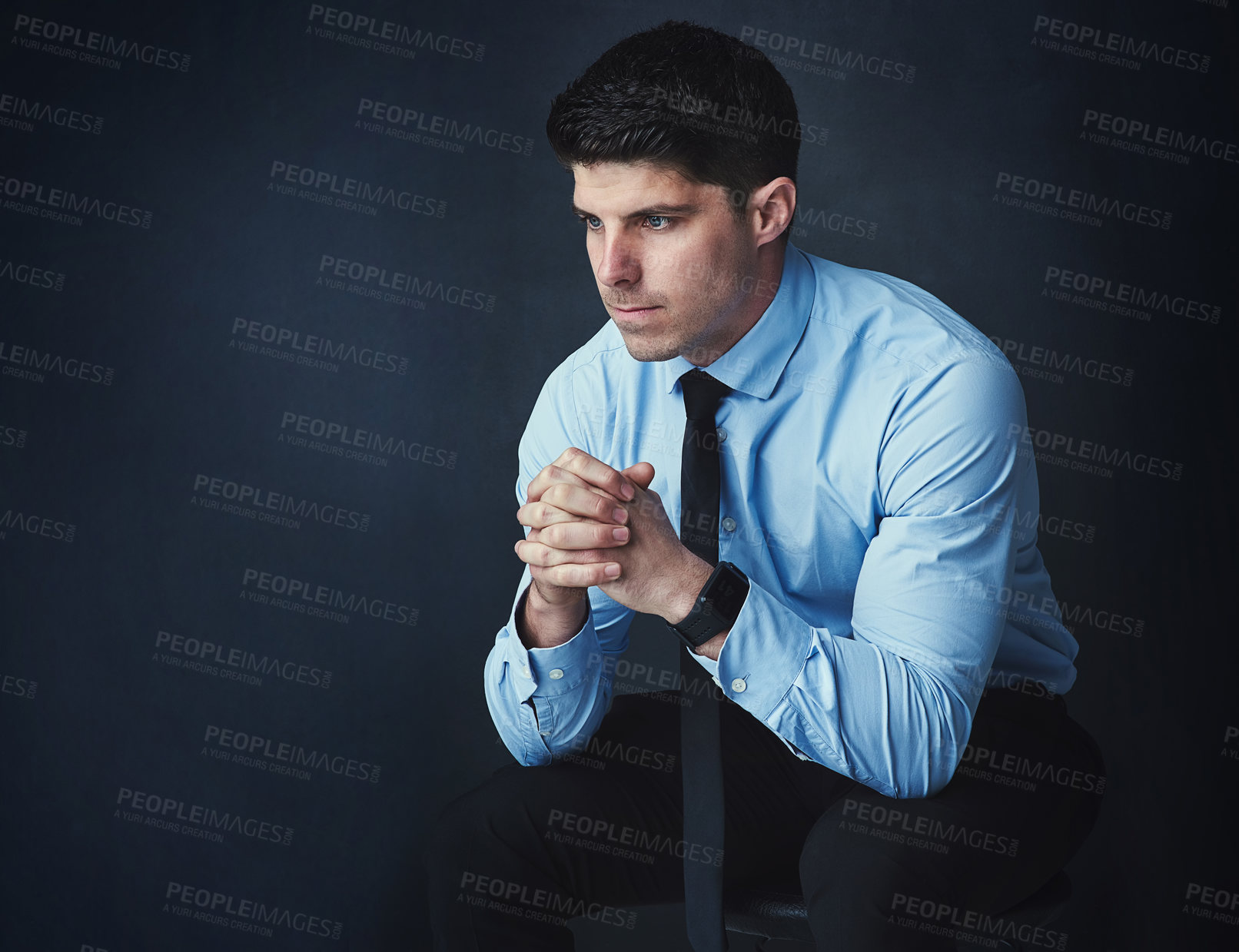 Buy stock photo Studio shot of a young businessman looking thoughtful against a dark background