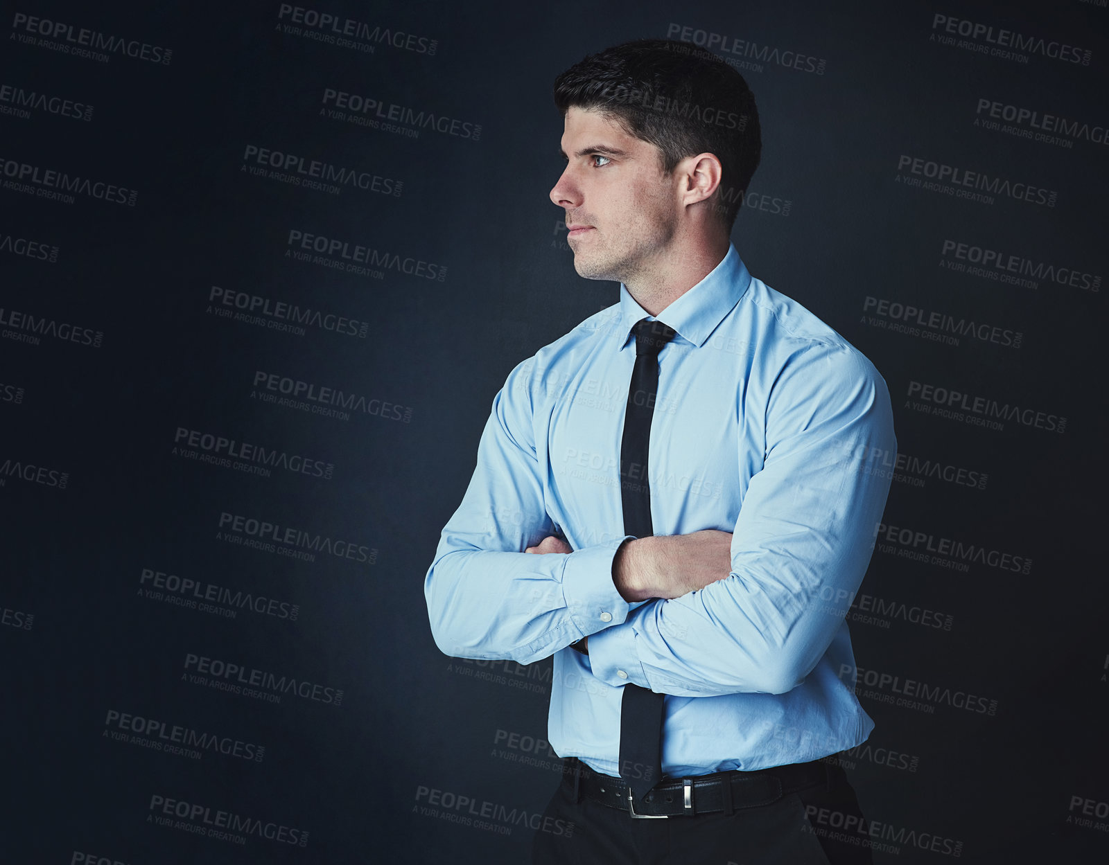 Buy stock photo Studio shot of a young businessman posing against a dark background