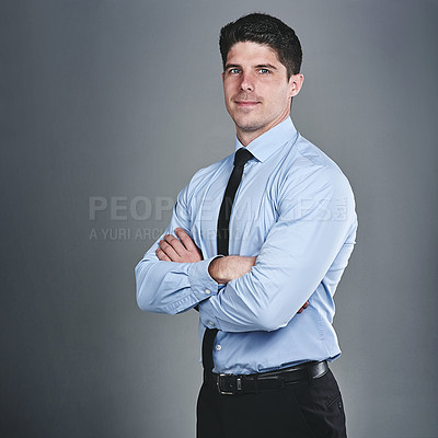 Buy stock photo Studio portrait of a young businessman posing against a grey background