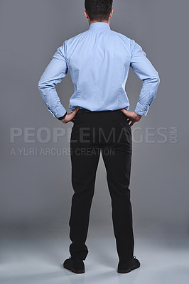 Buy stock photo Rearview studio shot of a young businessman standing against a grey background