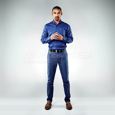 Buy stock photo Shot of a young businessman posing against a grey background