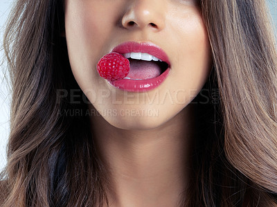 Buy stock photo Closeup shot of a beautiful woman biting on a raspberry