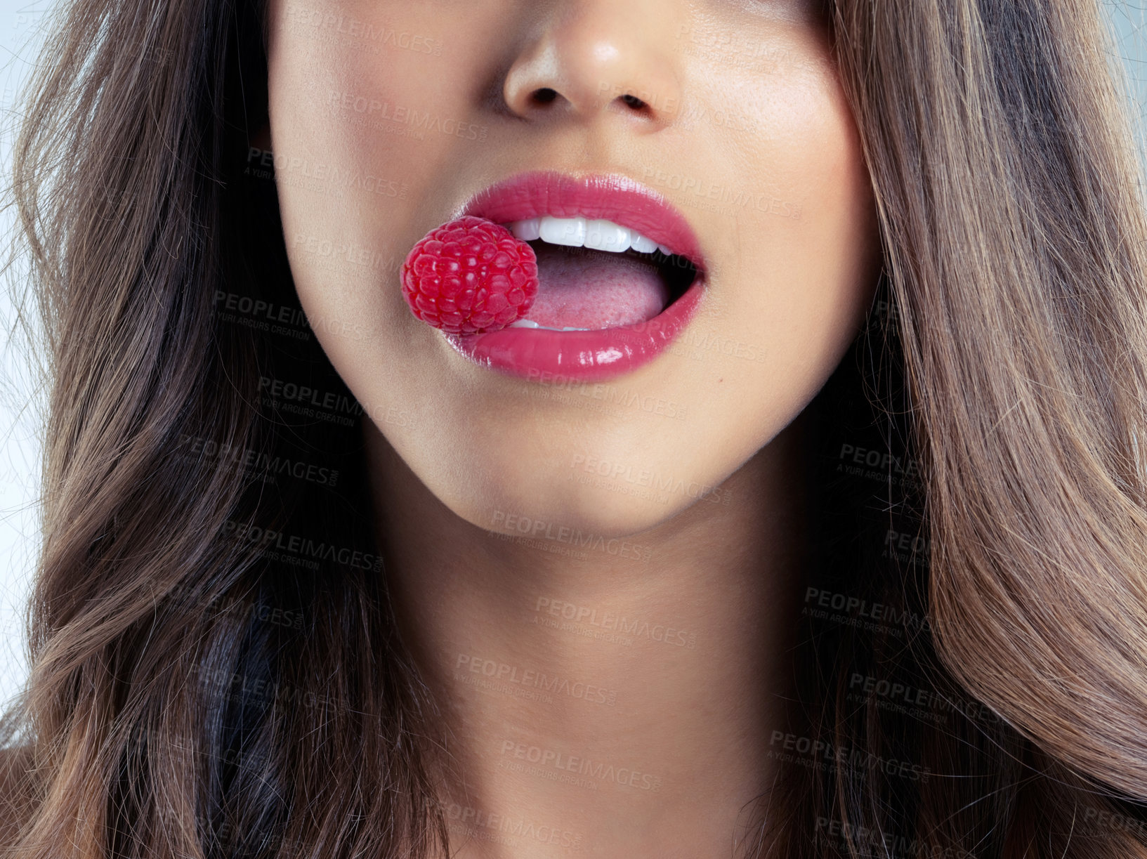 Buy stock photo Closeup shot of a beautiful woman biting on a raspberry