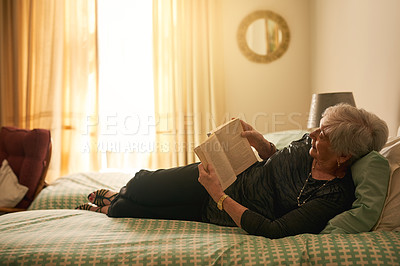 Buy stock photo Elderly woman, book and reading on bed for retirement with smile, wellness and learning for knowledge. Senior lady, happy and literature in nursing home with fiction story and hobby for entertainment