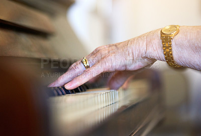 Buy stock photo Shot of an unidentifiable senior woman playing the piano at home