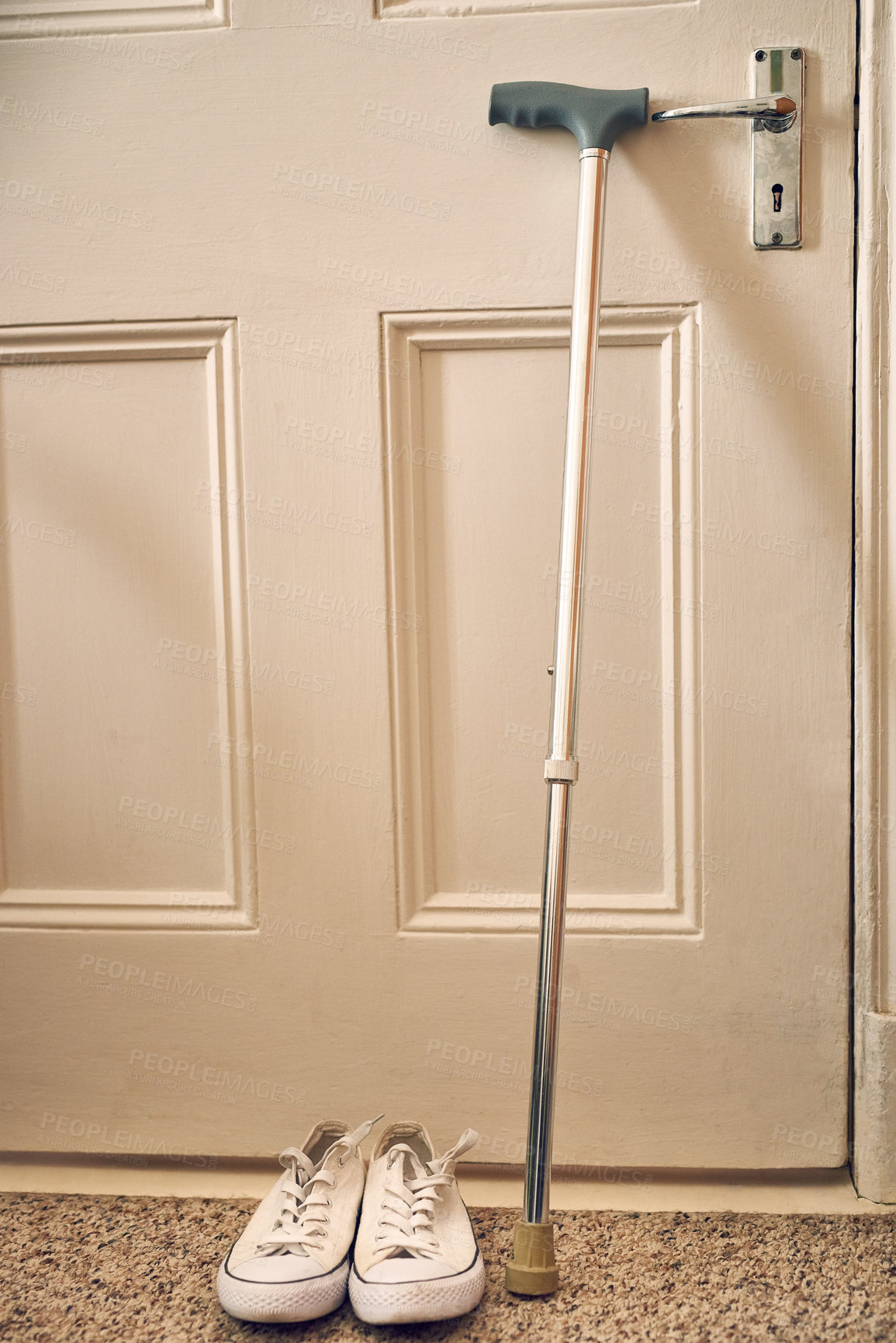 Buy stock photo Shot of a walking stick and shoes arranged by the door of an old age home