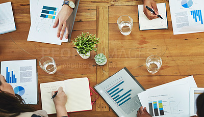 Buy stock photo High angle shot of designers working around a table in the office