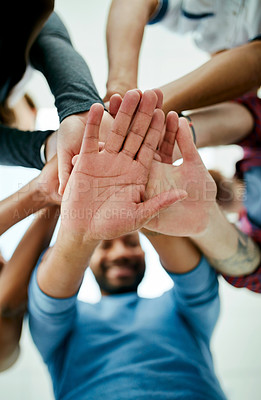 Buy stock photo Low angle shot of a young design team's hands in a huddle in their office