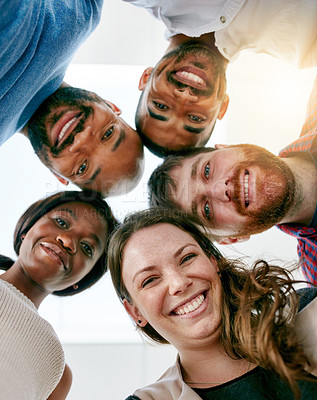 Buy stock photo Low angle portrait of a young design team standing in a huddle in their office