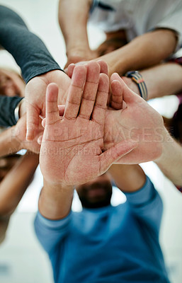 Buy stock photo Low angle shot of a young design team's hands in a huddle in their office