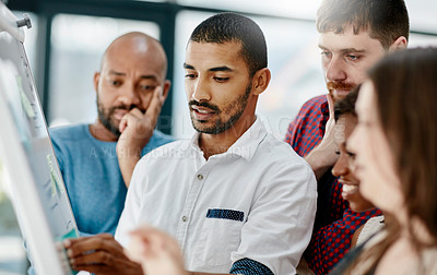 Buy stock photo Cropped shot of a young male designer giving an explanation to his team
