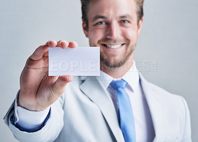 Buy stock photo Studio shot of a businessman holding up a blank business card against a grey background