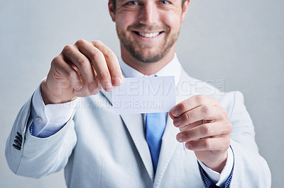 Buy stock photo Studio shot of a businessman holding up a blank business card against a grey background