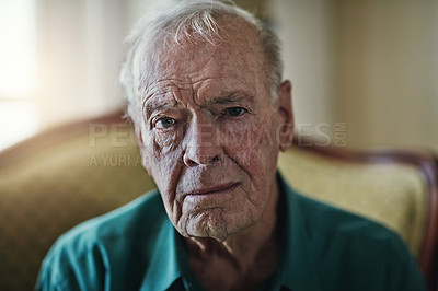 Buy stock photo Cropped shot of a senior man sitting by himself in a living room